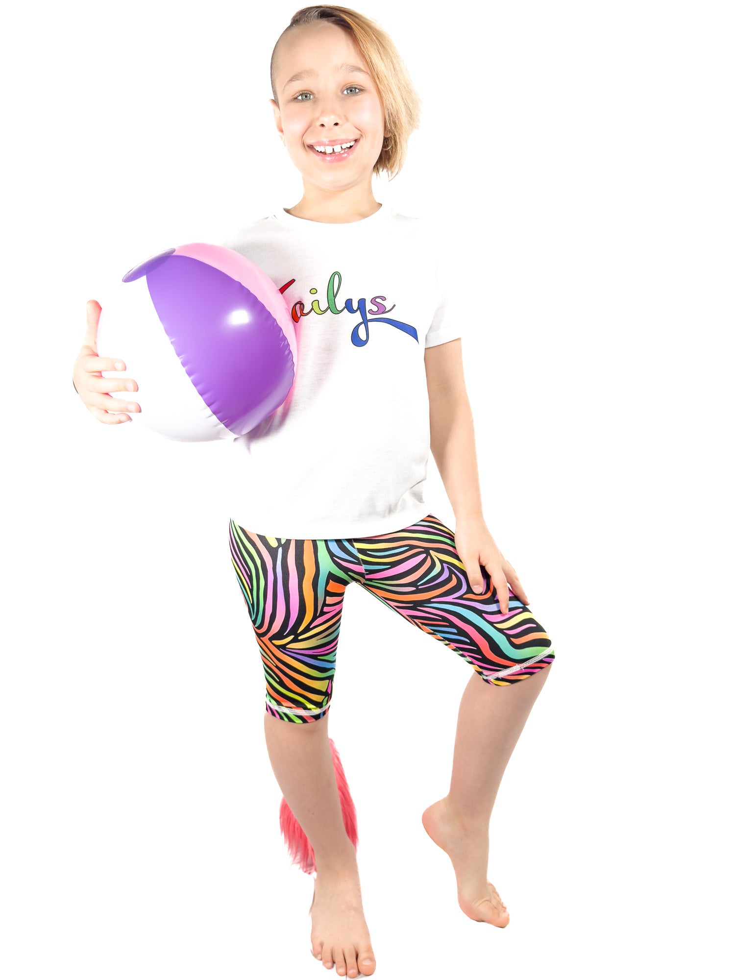 Girl with ball wearing Tailys kids shorts for girls rainbow zebra leggings tail pants.