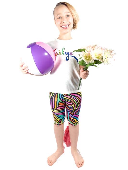 Girl with ball and flowers wearing Tailys kids shorts for girls rainbow zebra leggings tail pants.