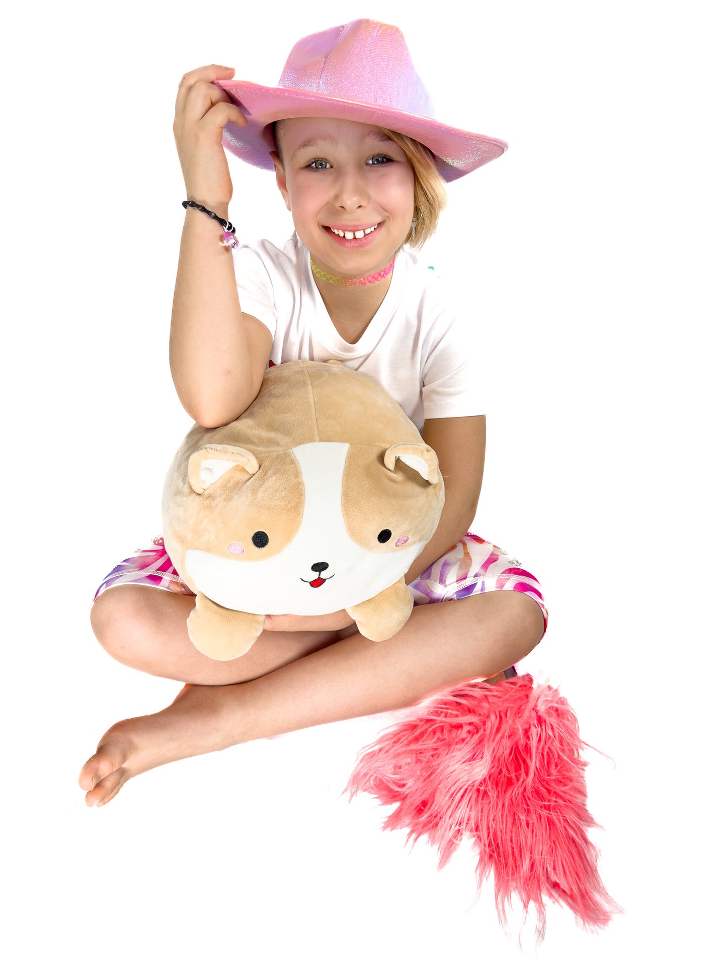 Cute girl sitting, hugging toy, wearing sparkly rhinestone pastel zebra shorts leggings with a tail by Tailys.