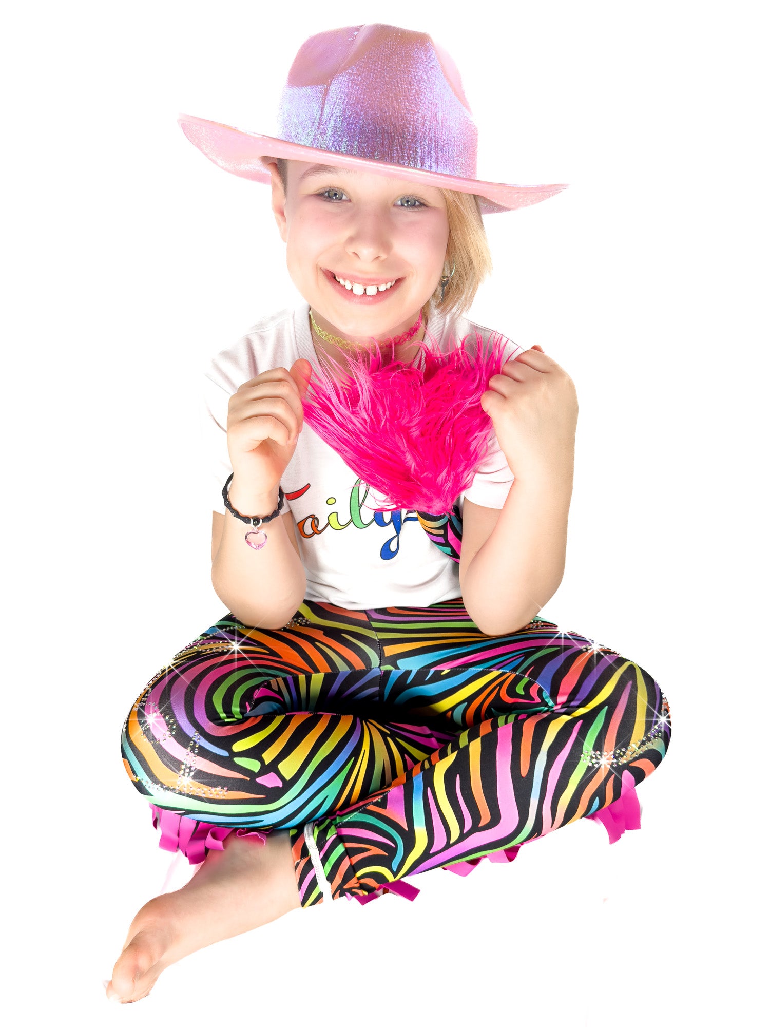Cute Girl sitting in rainbow zebra print frill leggings.