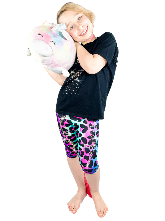 Girl with toy wearing Tailys sparkly rhinestone shorts for girls rainbow leopard leggings tail pants.